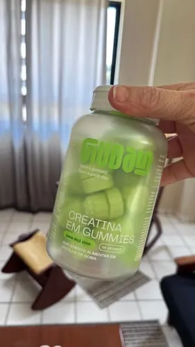 Pote de Creatina em Gummies Guday sabor maçã verde na mão